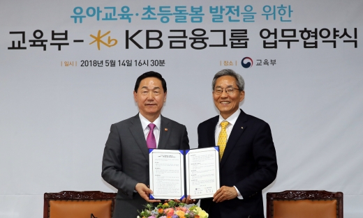 김상곤 사회부총리 겸 교육부 장관(왼쪽)과 윤종규 KB금융그룹 회장이 지난 14일 정부세종청사 교육부 대회의실에서 열린 '유아교육·초등돌봄 발전을 위한 교육부-KB금융그룹 업무협약식'을 마친 뒤 협약서를 들어보이고 있다. /사진=뉴스1