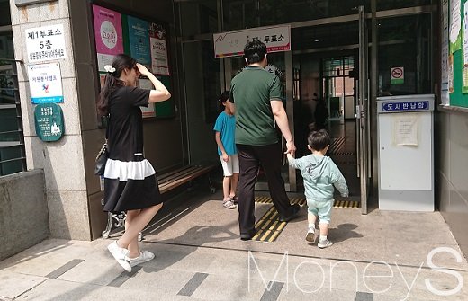 서울 난향동 주민센처에 설치된 제1투표소로 부부와 아이들이 들어가고 있다. /사진=박성필 기자