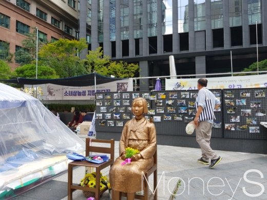 첫 일본군 '세계 위안부 피해자 기림의 날'을 맞이해 서울 종로구에서 퍼포먼스를 준비하고 있는 가운데 한 시민이 그 앞을 지나가고 있다. /사진=류은혁 기자