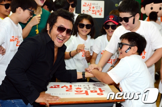 영화배우 김보성 씨가 지난해 6월30일 학교 폭력 예방 캠페인 '교실에서 찾은 희망' 우수학급인 서울 성북구 숭곡초등학교 5학년 4반 교실을 찾아 아이들과 '학교 폭력을 이긴다'는 의미를 담은 의리 팔씨름 대회를 하고 있다. /사진=뉴스1