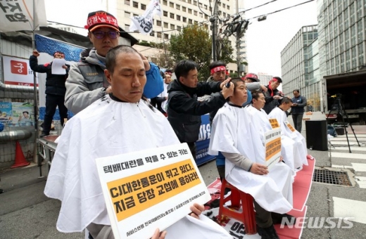  21일 오후 서울 중구 CJ대한통운 본사 앞에서 서비스연맹 전국택배연대노동조합, 공공운수연맹 전국택배노동조합 주최로 열린 택배노동자 총파업 대회에서 택배 기사들이 삭발을 하고 있다. /사진=뉴시스