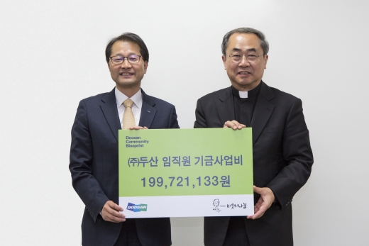 지난 15일 서울 명동성당에서 김윤건 두산 전무(왼쪽)가 손희송 재단법인 바보의나눔 이사장에게 회사 임직원이 모은 사회공헌 기부금 약 2억원을 전달한 뒤 기념촬영을 하고 있다. / 사진=두산