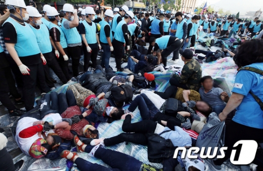 서울시와 용역업체 직원들이 25일 오전 서울 종로구 광화문광장에 설치된 대한애국당의 농성 천막을 철거하려 하자 당원들이 바닥에 드러누워 저항하고 있다. /사진=뉴스1