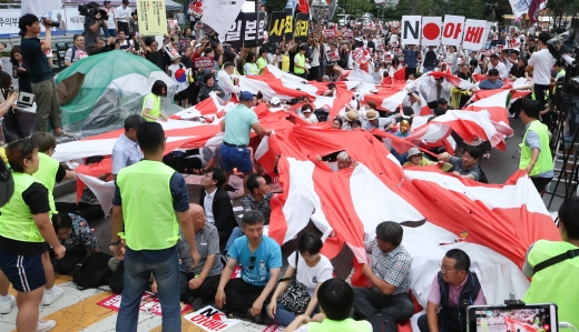 20일 서울 종로구 옛 일본대사관 앞에서 열린 아베정부 규탄대회에서 참석자들이 경제 보복 조치를 규탄하며 일제 전범기인 '욱일승천기'를 찢고 있다. /사진=뉴스1