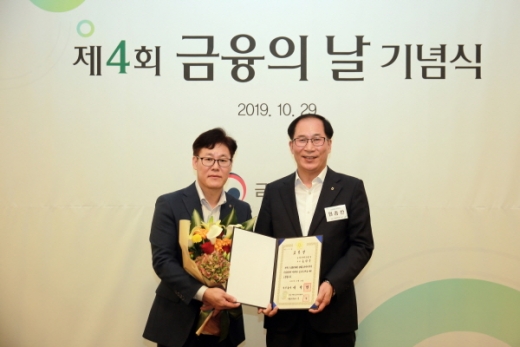 국무총리상 수상의 영예를 안은 송원주 고객지원부 팀장(왼쪽)이 원종찬 영업지원부문 부문장과 기념사진을 찍고 있다.