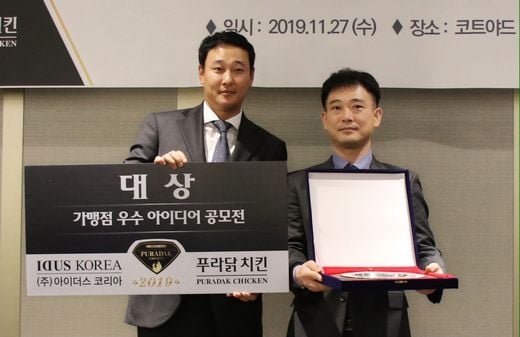▲아이더스코리의 장성식 대표이사(왼쪽)와 푸라닭 대구지산점 장경한 사장님이 '가맹점 우수 아이디어 공모전'에서 홍보 주제로 대상을 수상한 뒤 기념사진을 찍고 있다. (사진제공= (주)아이더스코리아)