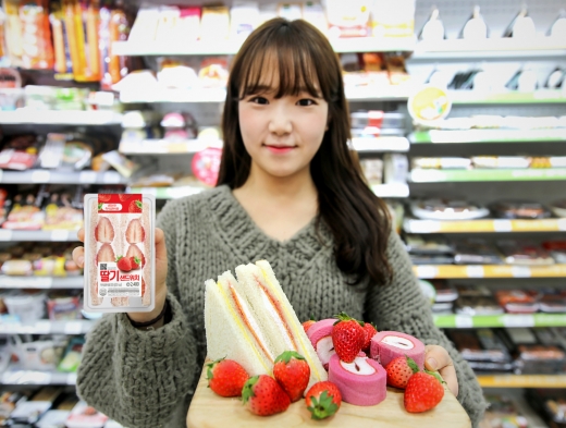 모델이 딸기샌드위치와 딸기 Berry Much 행사품을 들고 포즈를 취하고 있다./사진=GS리테일