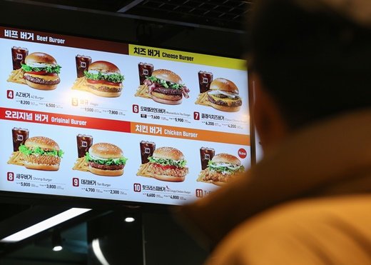 서울의 한 햄버거 프랜차이즈에서 소비자가 메뉴판을 들여다보고 있다. /사진=뉴스1 DB