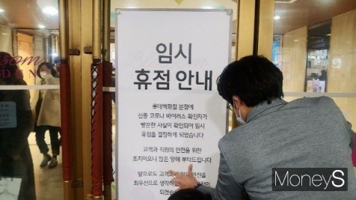 신종 코로나바이러스 감염증 확진자가 다녀간 것으로 알려진 롯데백화점 본점에서 7일 오후 백화점 관계자가 임시휴점 안내 공지를 붙이고 있다. /사진=독자제공 