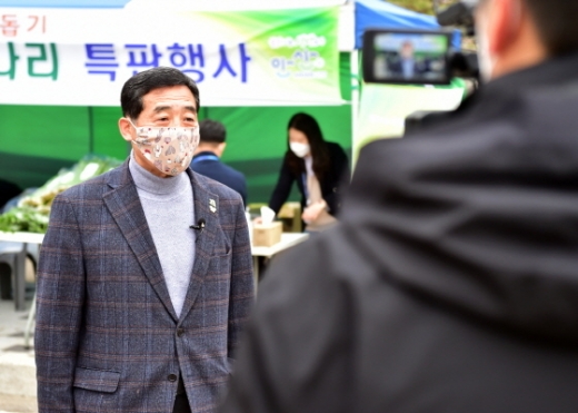 윤화섭 안산시장이 한재미나리 특판행사에서 자원봉사자표 수제 면 마스크를 착용하고 인터뷰를 진행하고 있다. / 사진제공=안산시