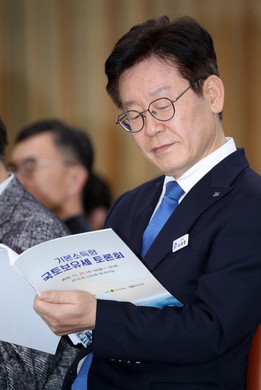이재명 경기지사가 21일 열린 기본소득형 국토보유세 토론회에서 자료집을 보고 있다. / 사진제공=경기도