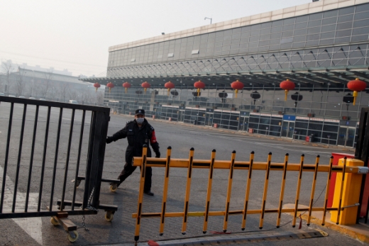 베이징에서 코로나19 확산으로 시내버스 운행이 중단되자 보안요원이 문을 닫고 있다.©로이터=뉴스1 