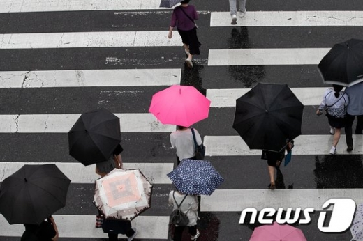 서울 광진구의 한 거리에서 시민들이 우산을 쓰고 발걸음을 옮기고 있다./사진=뉴스1