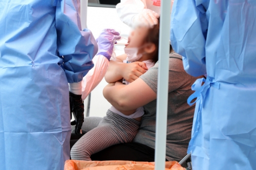 광주 동구청 드라이브스루 선별진료소에서 의료진이 한 어린이를 대상으로 코로나19 진단검사를 실시하고 있다. /사진=뉴스1