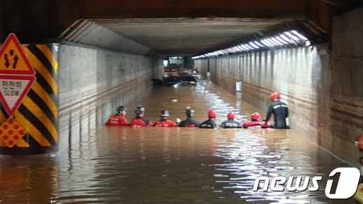 부산 폭우로 동구초량 제1지하차도가 물에 잠기면서 3명이 숨졌다. 119 구조대원들이 일렬로 서서 물에 빠진 사람이 있는지 수색하고 있다.(부산경찰청 제공).2020.7.24/뉴스1 © News1 박세진 기자