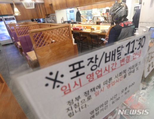 30일 밤 9시가 넘어선 시각, 방역 강화 조치로 문 닫은 매장에 배달기사가 들어가고 있다. /사진=뉴시스