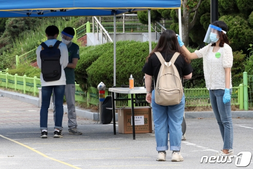 신한카드와 국민카드, 삼성카드는 올 하반기 공개채용을 진행키로 가닥을 잡았지만 코로나19 재확산에 따라 세부 일정을 확정하지 못했다. 현대카드와 롯데카드, 우리카드, 하나카드 등은 올 하반기 공채 계획이 미정이다. 사진은 지난 6월 서울 영등포구 여의도 윤중중학교에서 지방공무원 8·9급 공채시험 응시자들이 고사장으로 향하며 체온 측정과 손소독을 받는 모습./사진=뉴스1