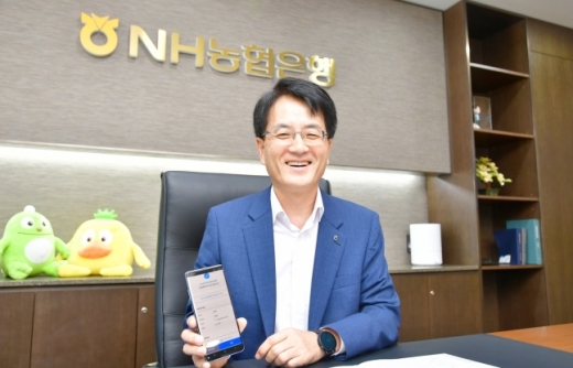 7일 서울 중구 NH농협은행 본점에서 손병환 은행장이 스마트뱅킹을 통해 직접 NH운전자상해보험을 가입하고 있다.