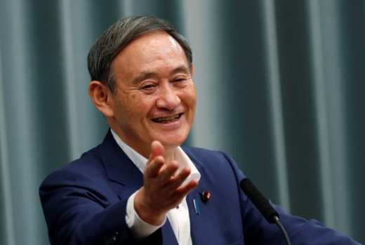 스가 요시히데 일본 관방장관이 14일 도쿄 총리관저에서 열린 기자회견에서 손을 올리며 웃음을 보이고 있다. /사진=로이터