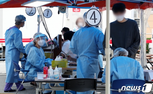 15일 오전 서울 강남구 보건소에 마련된 선별진료소에서 의료진이 검체체취를 하고 있다. /뉴스1 © News1 이동해 기자