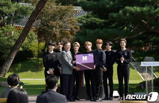 문재인 대통령이 19일 오전 청와대 녹지원에서 열린 제1회 청년의 날 기념식에서 방탄소년단(BTS)에게 2039년 청년들에게 전하는 선물을 받고 있다. 2020.9.19/뉴스1 © News1 박정호 기자