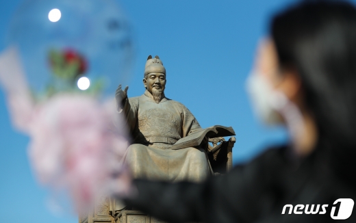 제574돌 한글날을 하루 앞둔 8일 서울 광화문 광장에서 한 시민이 꽃다발을 세종대왕 동상을 향해 들어보이고 있다. 2020.10.8/뉴스1 © News1 허경 기자