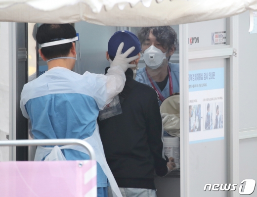 지난 13일 오후 서울 중구 국립중앙의료원에 마련된 선별진료소에서 의료진들이 내원객에게 신종 코로나바이러스 감염증(코로나19) 검체 채취를 하고 있다. /사진=뉴스1