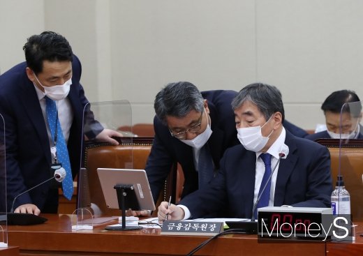 윤석헌 금융감독원장이 23일 국회 정무위원회 종합감사 시작 전 관계자들과 이야기를 나누고 있다. 윤 원장과 은성수 금융위원장은 이날 무저해지보험의 불완전판매 가능성을 인정하며 문제점을 고쳐나가겠다고 밝혔다./사진=임한별 기자