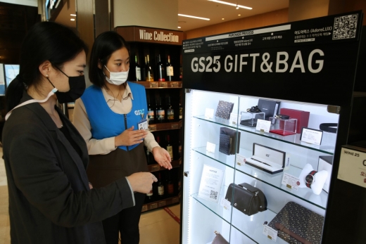 GS25 파르나스타워점 직원이 고객에게 명품 판매대에서 제품 설명을 진행하고 있다. /사진=GS25 제공 