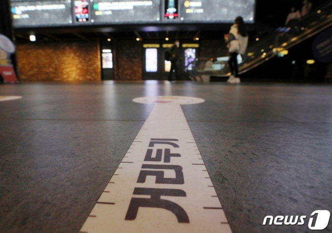 코로나19 확진자가 속출하며 거리두기 격상이 임박한 분위기다. 사진은 지난 18일 오후 서울 CGV용산에 거리두기 문구가 붙은 모습. /사진=뉴스1