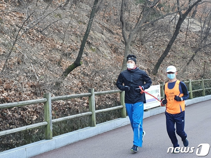 전맹(全盲) 장애인 마라토너 정운로씨(50)와 그를 돕는 동반주자 조성수씨(30)가 남산을 달리고 있다. © 뉴스1/정혜민 기자
