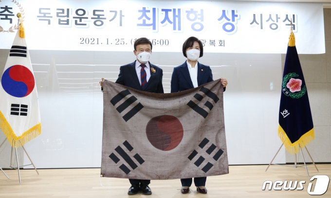 지난 25일 서울 여의도 광복회관에서 열린 '독립운동가 최재형상' 시상식에서 '최재형상'을 받은 추미애 법무부 장관이 김원웅 광복회장과 임시의정원 걸개 태극기를 들고 기념 촬영을 하고 있다. (광복회 제공) 2021.1.25/뉴스1 © News1 송원영 기자