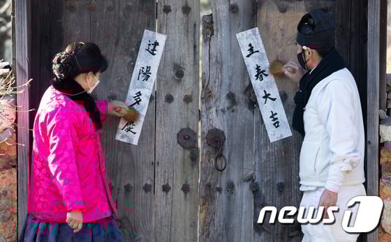 오늘(3일)은 절기상 입춘이다. 사진은 입춘을 하루 앞둔 지난 2일 오후 경기도 용인시 기흥구 한국민속촌에서 어르신들이 '입춘대길)'立春大吉)과 '건양다경'(建陽多慶)이 적힌 입춘방을 붙인 모습. /사진=뉴스1