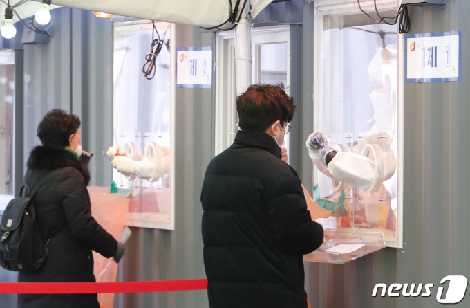 19일 오전 서울 중구 서울역 앞에 마련된 임시선별검사소에서 의료진들이 검체 검사를 하고 있다. 2021.2.19/뉴스1 © News1 송원영 기자