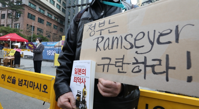 지난 10일 오후 서울 종로구 옛 일본대사관 앞에서 열린 1482차 일본군 성노예제 문제 해결을 위한 정기 수요시위에서 한 참석자가 '위안부는 자발적 매춘부'라고 역사를 왜곡한 마크 램지어 하버드대 로스쿨 교수를 규탄하는 피켓을 들고 있다. /사진=뉴스1 임세영 기자