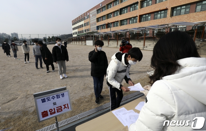 올 11월18일 시행되는 2022학년도 대학수학능력시험에서는 국어와 수학, 직업탐구 영역에도 선택과목이 생긴다. 사진은 지난해 12월 울산 중구 약사고등학교 운동장에서 2021학년도 대학수학능력시험 성적표를 배부받고 있는 수험생들의 모습. /사진=뉴스1