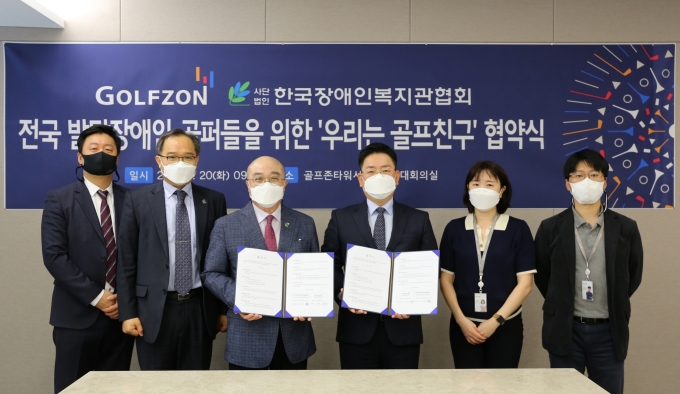 골프존은 지난달 4월 20일(화) 골프존타워서울에서 한국장애인복지관협회와 전국 발달장애인 골퍼들을 위한 ‘우리는 골프친구’ 협약식을 진행했다. 사진은 협약식에 참석한 (왼쪽부터) 한국장애인복지관협회 유승훈 과장, 이상진 사무총장, 조석영 회장, 골프존 기획실 박영욱 실장, 경영기획팀 김지영 프로, 남희철 팀장이 기념사진을 촬영하고 있다. (골프존 제공)