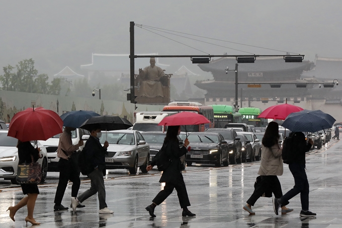 목요일(27일)은 전국에 돌풍과 천둥·번개를 동반한 강한 비가 내린다. 사진은 지난 25일 우산을 쓰고 출근하는 시민들. /사진=뉴스1