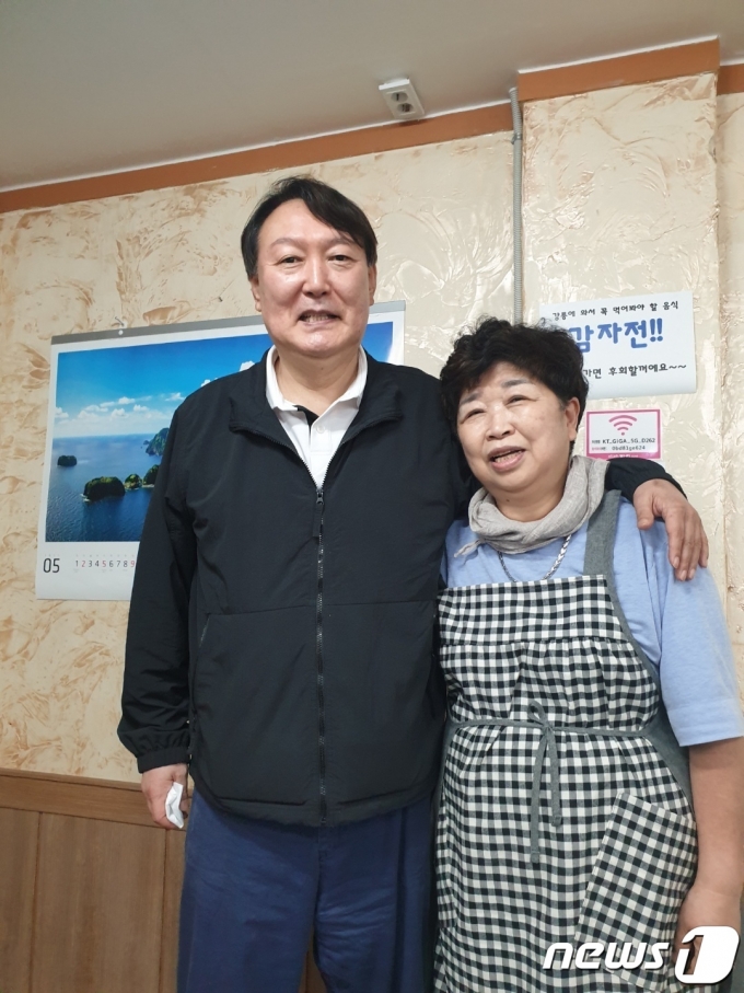 지난 29일 강원 강릉을 방문한 윤석열 전 검찰총장이 강릉중앙시장 내 감자바우 식당에서 이경숙 사장과 사진촬영을 하고 있다.(이경숙씨 제공).2021.5.31./뉴스1