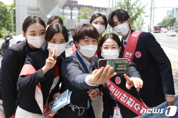 지난달 24일 선거운동을 위해 대구에 내려간 이준석 국민의힘 당대표 후보가 경북대학교 북문 앞에서 대학생들과 인사 나누며 기념사진을 찍고 있다. 마치 연예인과 팬들의 만남과 같은 분위기를 자아냈다.. © News1