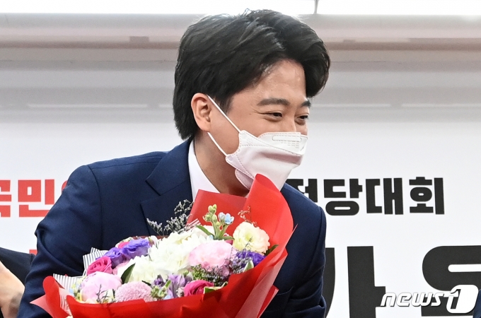 이준석 국민의힘 신임 대표가 11일 서울 여의도 국민의힘 당사에서 열린 전당대회에서 당선 확정 후 꽃다발을 받고 있다. 2021.6.11/뉴스1 © News1 오대일 기자