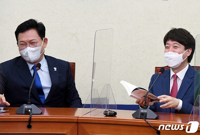 이준석 국민의힘 대표(오른쪽)가 17일 오후 서울 여의도 국회에서 송영길 더불어민주당 대표를 예방해 송 대표의 저서를 선물 받고 서로 웃고 있다. 2021.6.17/뉴스1 © News1 구윤성 기자