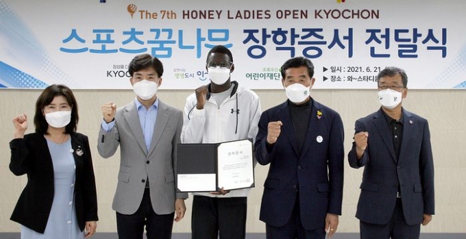 교촌치킨을 운영하는 교촌에프앤비㈜가 지난 21일(월) 경기도 안산 와스타디움에서 안산시 스포츠 유망주를 위한 장학금 전달식을 진행했다. 이날 행사에 참석한 참석자들이 수혜자 대표인 육상 유망주 ‘비웨사 다니엘 가사마’와 기념사진 촬영을 하고 있다. (왼쪽부터) 김창연 초록우산어린이재단 경기지역본부장, 임형욱 교촌에프앤비 대외협력부문장, 비웨사 다니엘 가사마, 윤화섭 안산시장, 배정완 안산시체육회 회장 (사진제공=교촌에프앤비(주))