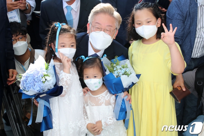 대선 출마를 선언한 이재명 경기도지사가 1일 오후 고향인 경북 안동을 찾아 경상북도유교문화회관에서 꽃다발을 들고 환영 나온 어린이들과 기념사진을 찍고 있다. 2021.7.1/뉴스1 © News1 공정식 기자