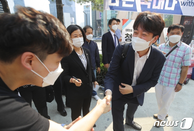 이준석 국민의힘 대표가 20일 오후 서울 강남역 인근을 찾아 시민들과 악수를 나누고 있다. 2021.6.20/뉴스1 &copy; News1 이동해 기자