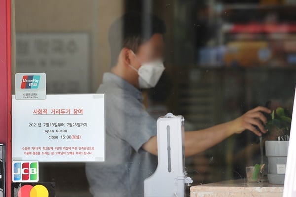 코로나19 신규 확진자가 14일 0시 기준 1600명에 육박할 전망이다. 사진은 지난 13일 서울 시내의 한 식당에 거리두기 4단계 격상에 따른 영업시간 단축 안내문이 붙은 모습. /사진=뉴스1