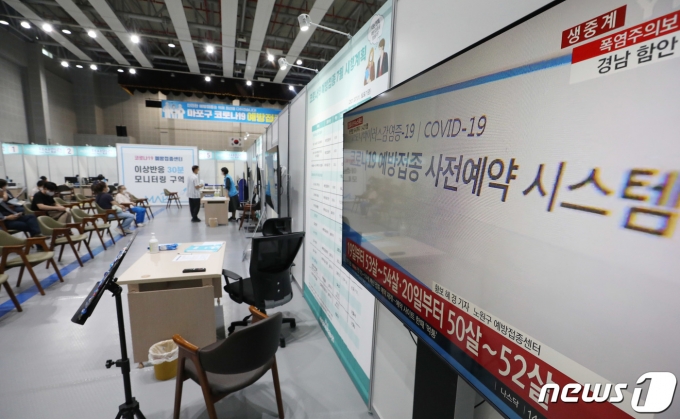 15일 오전 서울 마포구 코로나19 예방접종센터 이상반응 모니터링 구역에 설치된 텔레비전에 '50대 초반 19일부터 분산 예약 시행' 관련 뉴스가 나오고 있다.  2021.7.15/뉴스1 © News1 박정호 기자