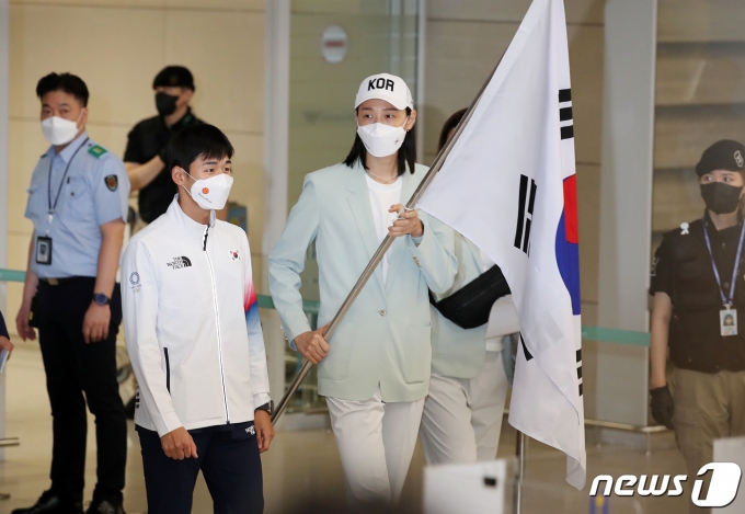 근대5종 전웅태와 여자 배구대표팀 김연경이 9일 오후 인천국제공항 제2터미널에서 열린 2020 도쿄올림픽 대한민국 선수단 환영 행사에 앞서 태극기를 들고 입장하고 있다. 2021.8.9/뉴스1 © News1 김진환 기자