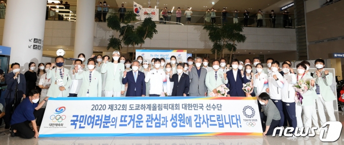 9일 오후 인천국제공항 제2터미널에서 열린 2020 도쿄올림픽 대한민국 선수단 환영 행사에서 이기흥 대한체육회장을 비롯한 귀빈들과 선수들이 기념촬영을 하고 있다. 2021.8.9/뉴스1 © News1 김진환 기자