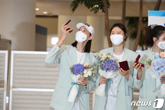 여자 배구대표팀 주장 김연경이 2020 도쿄올림픽 일정을 마치고 9일 오후 인천국제공항을 통해 입국, 배구협회가 제작한 기념주화를 바라보고 있다. 2021.8.9/뉴스1 © News1 김진환 기자